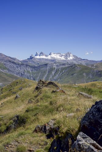 Scenic view of alpine landscape with the ridges of "Aiguilles d'Arves" in the background (with snow), Oisans, Isere, France