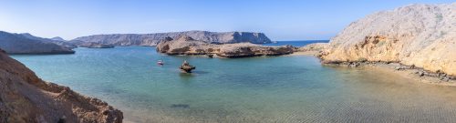 Panoramic view of the wild Coast of Bandar Khairan with clear water of the ocean and the arid mountains, Sultanate of Oman