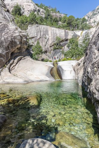 people canyoning in the famous Purcaraccia Canyon in Bavella during summer, a tourist destination and attraction for canyoning, hiking and visiting the natural pools. Corsica, France