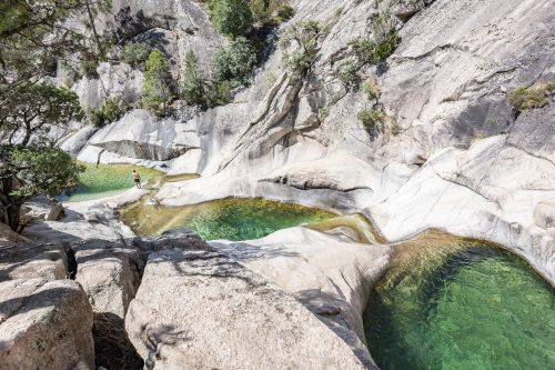 people enjoying the famous natural Pools of Purcaraccia Canyon in Bavella during summer, a tourist destination and attraction for canyoning and hiking. Corsica, France