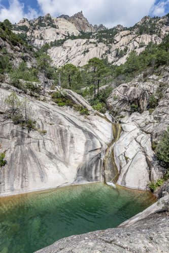 Waterfall and natural pool in Purcaraccia Canyon in Bavella during summer. You will go through clear waters with amazing natural slides. Corsica, France