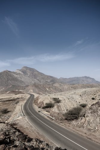 A road going thru the deserted mountains of the Sultanate of Oman 